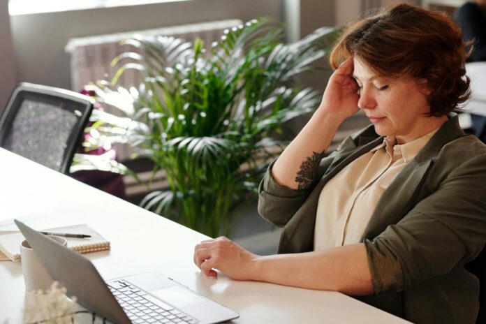 woman holding her head in pain - a personal injury while working from home